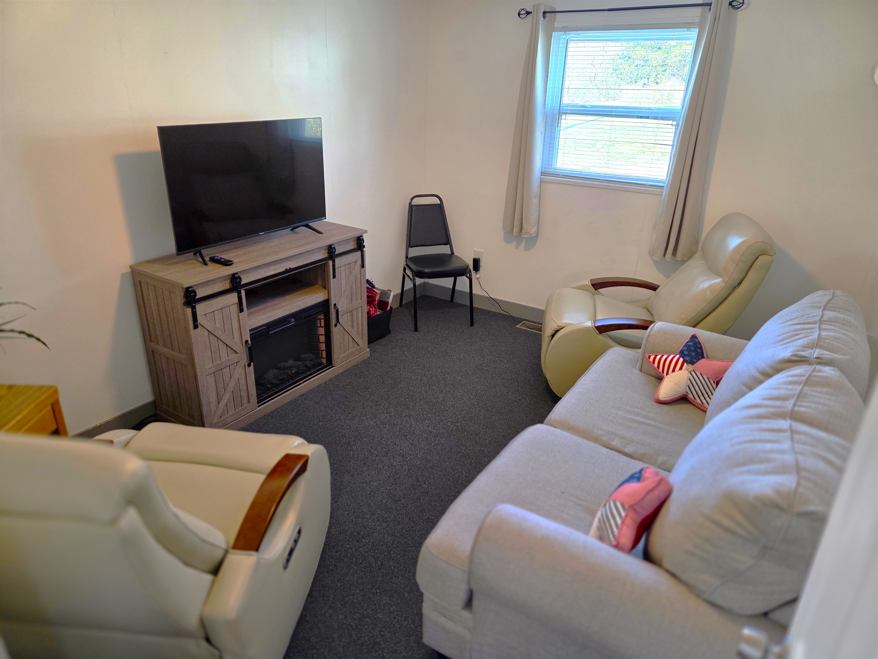 The living room features a smart TV, 2 recliners, sofa, and fireplace for ambiance.