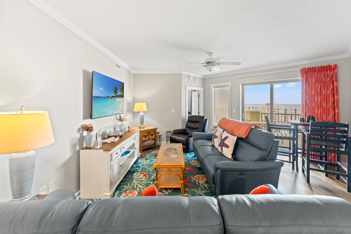 Living room are with plenty of seating and large TV with balcony access