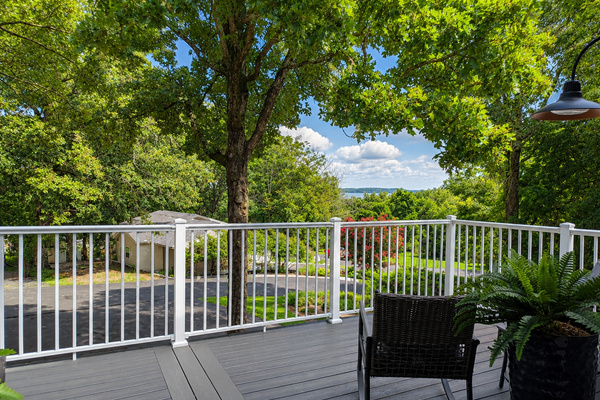 Upper-level deck with peaceful lake views, outdoor seating and a relaxing spot to enjoy the wooded setting.