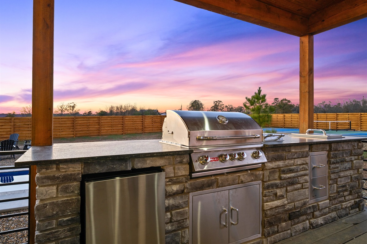 This full outdoor kitchen setup gives you everything you need to cook and enjoy meals under the open sky.