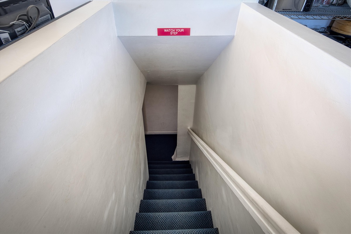 Stairs to the game room located in the kitchen to the left of the pantry.