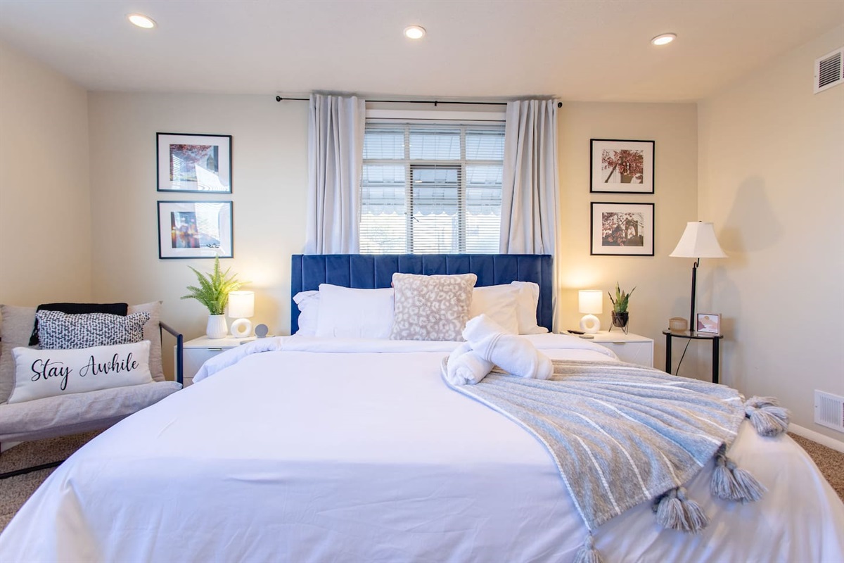 Cozy, spacious room with a queen-sized bed, TV, and a dedicated working space.