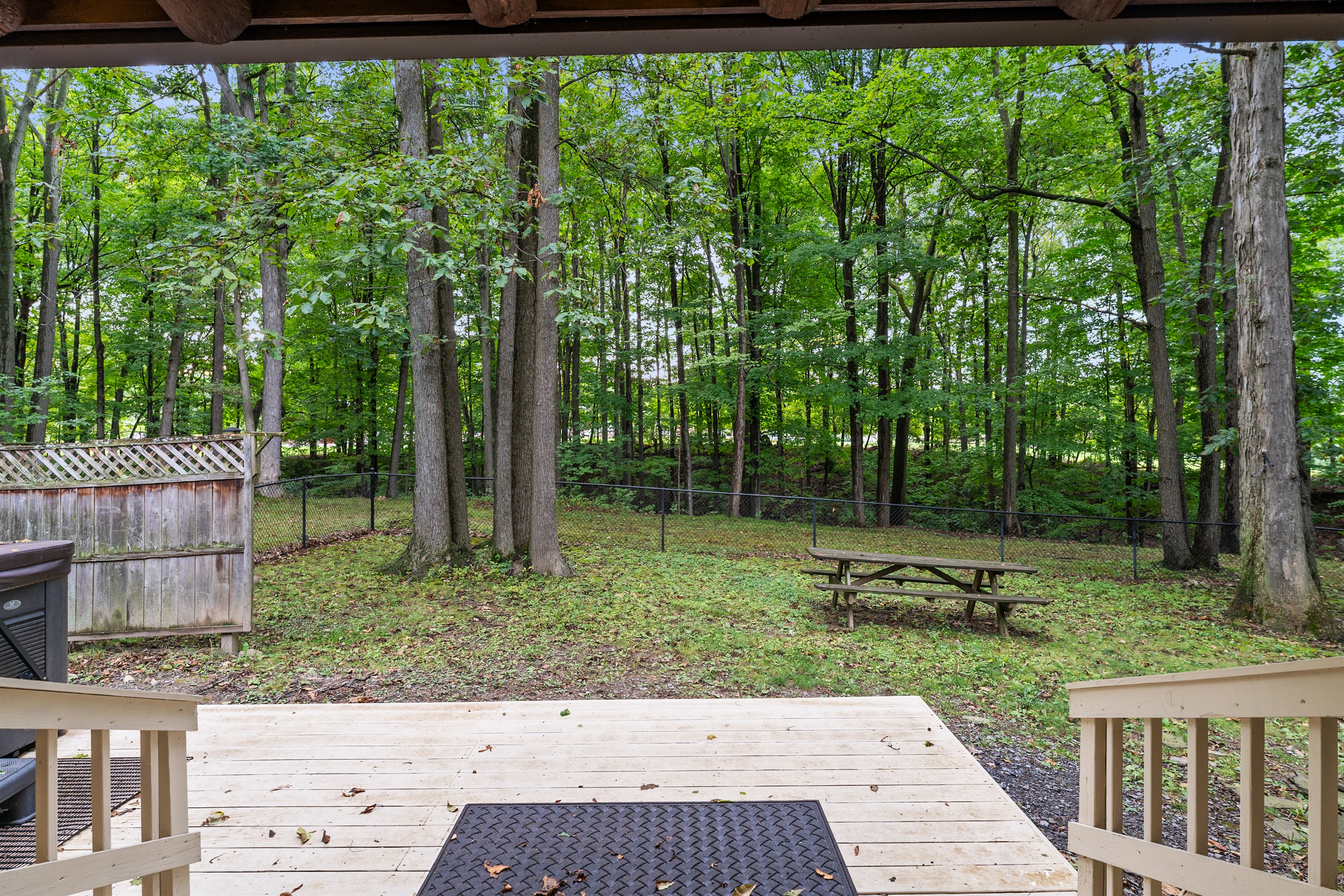 Relax in the private, fenced backyard surrounded by tall trees, complete with a picnic table for outdoor meals and space to soak in nature.