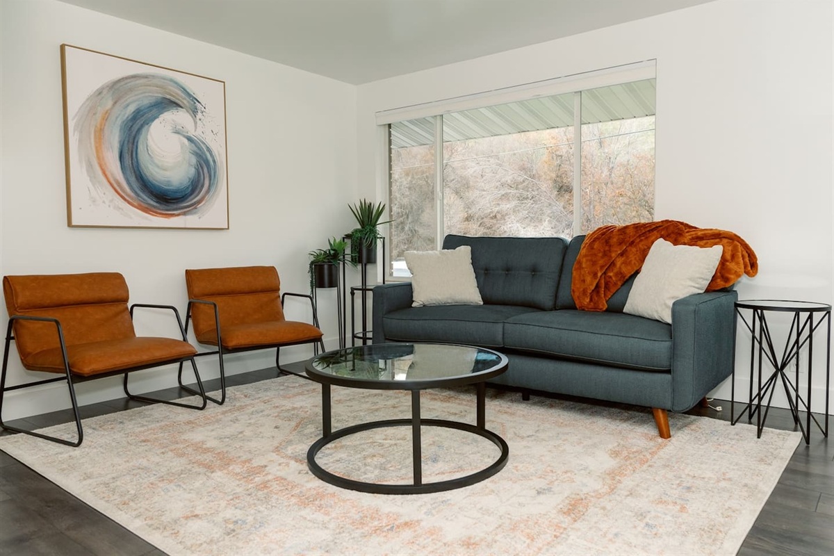 Cozy living room with large window and open to the dining room and kitchen.