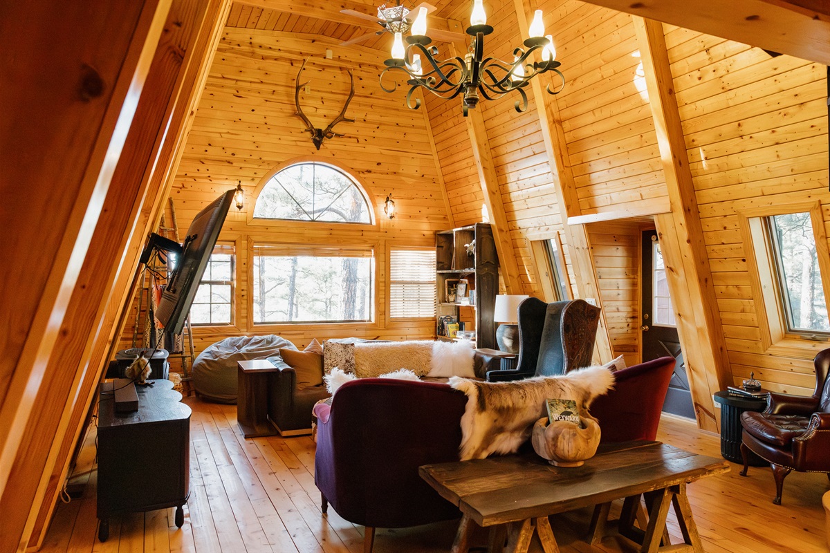 Soaring cathedral ceilings and gothic western charm define Poppywood Pines' living space. This unique Show Low A-frame cabin features cozy furnishings, natural light, and authentic mountain decor. Your perfect White Mountains retreat for family gatherings.