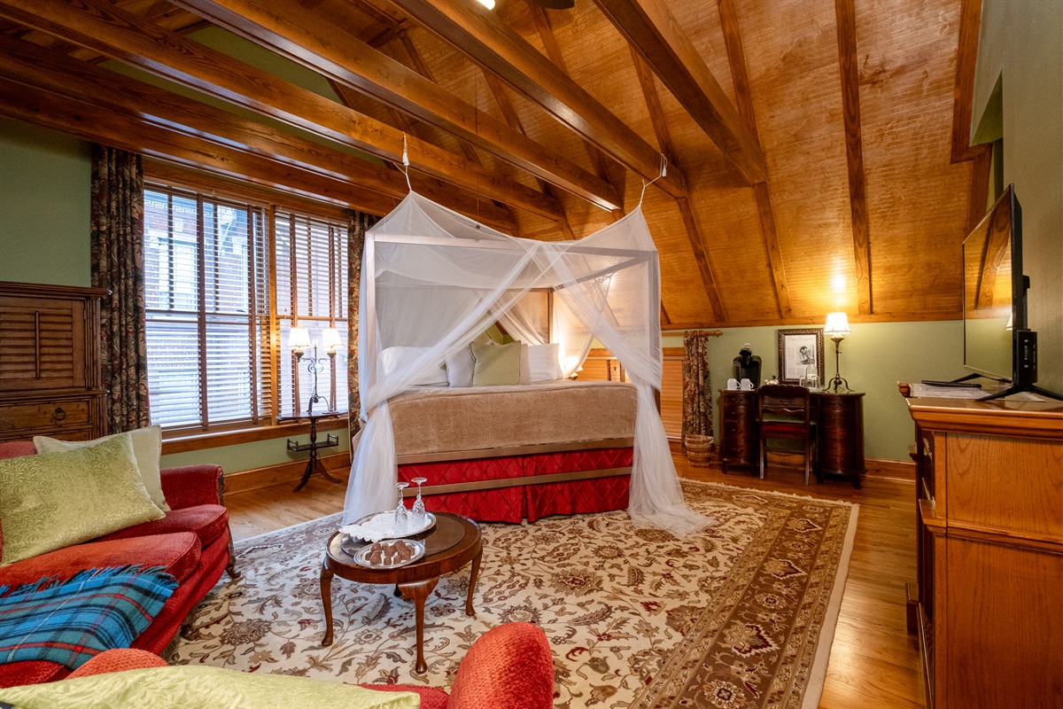 Wide view of the suite showcasing the vaulted ceiling, seating area, and refined, lodge-inspired character.