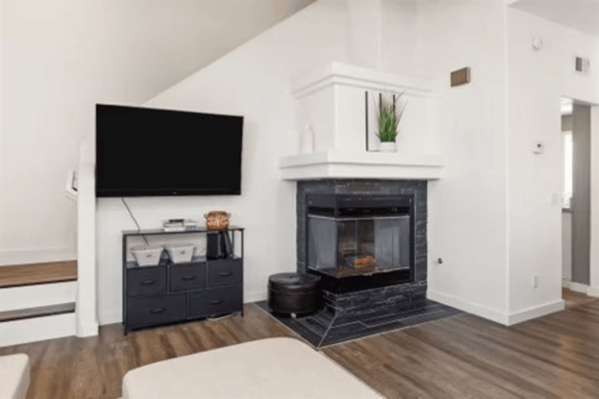 Bright living area with oversized windows, cozy sectional seating, Smart TV, and high-speed WiFi for streaming and relaxing.