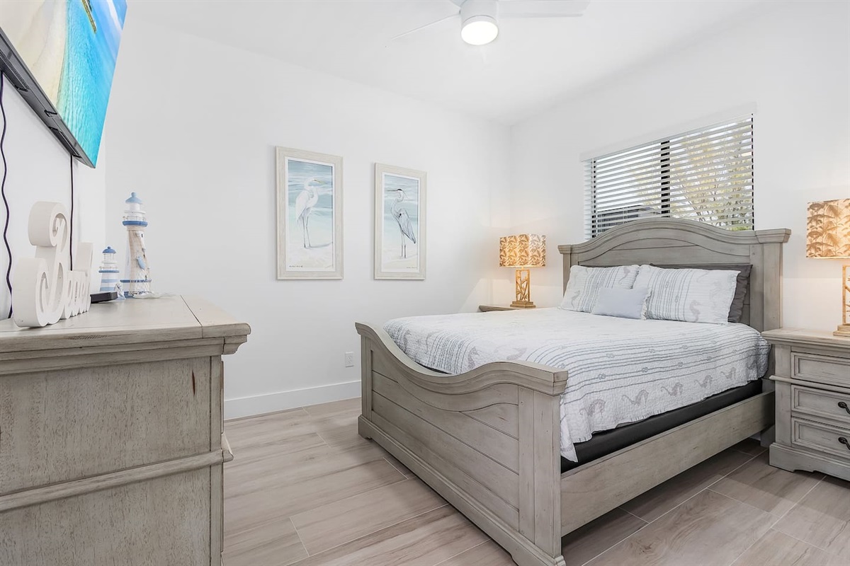 2nd  Guest bedroom with a queen-size bed, TV, and comfortable coastal-designed bedding for a relaxing stay!