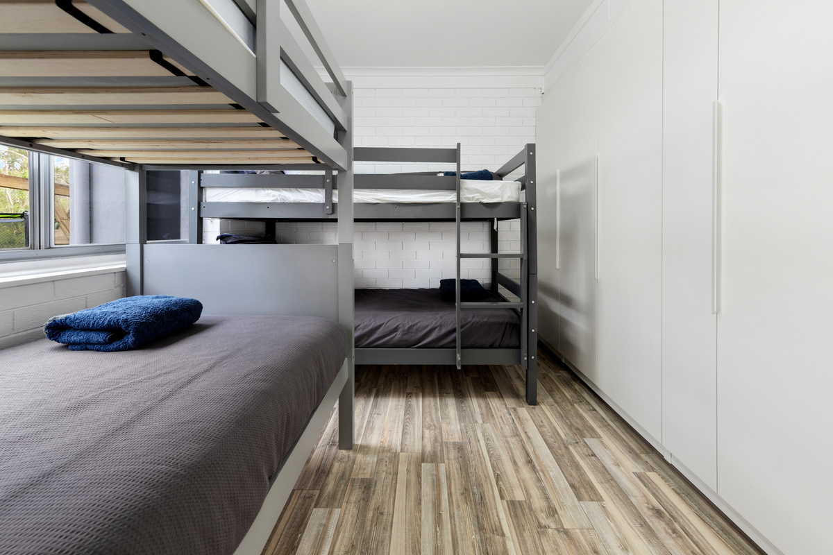 This downstairs bunk bedroom expands the two-level setup at Skye’s Beach House, adding a dedicated sleeping zone beside the lower living spaces.