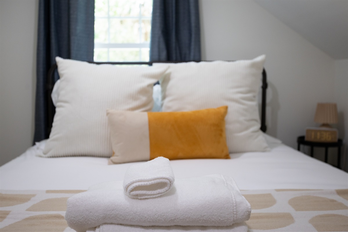 Drift off in a plush bed layered with extra pillows—because comfort is always in style.