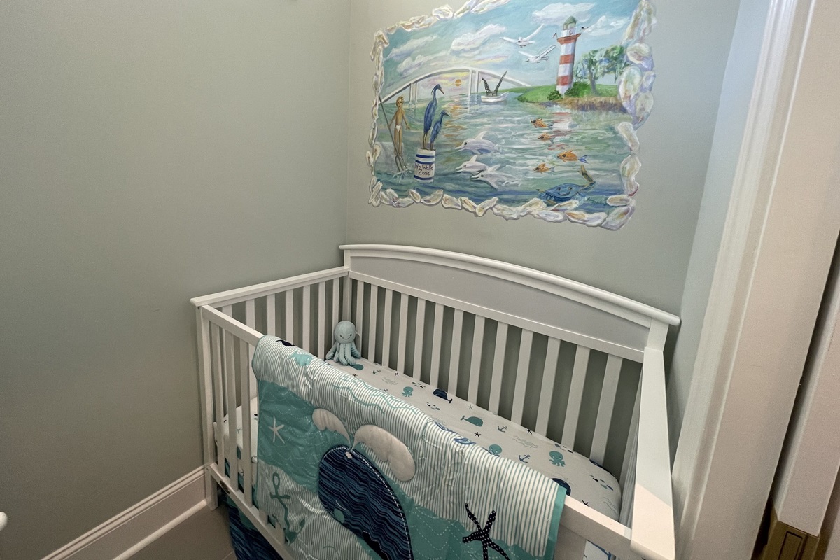 Nursery area with crib and changing table between Primary bedroom and bathroom