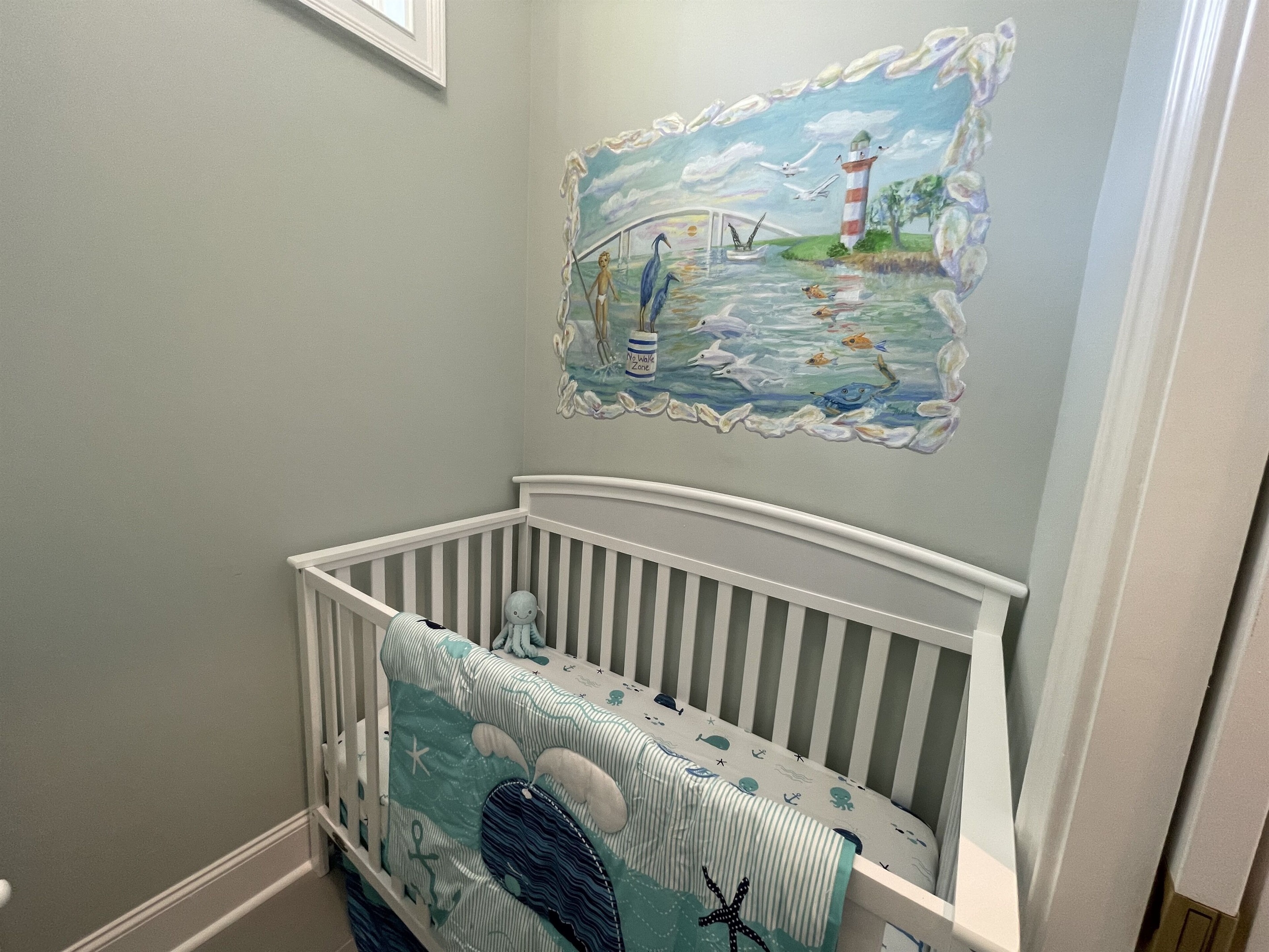 Nursery area with crib and changing table between Primary bedroom and bathroom
