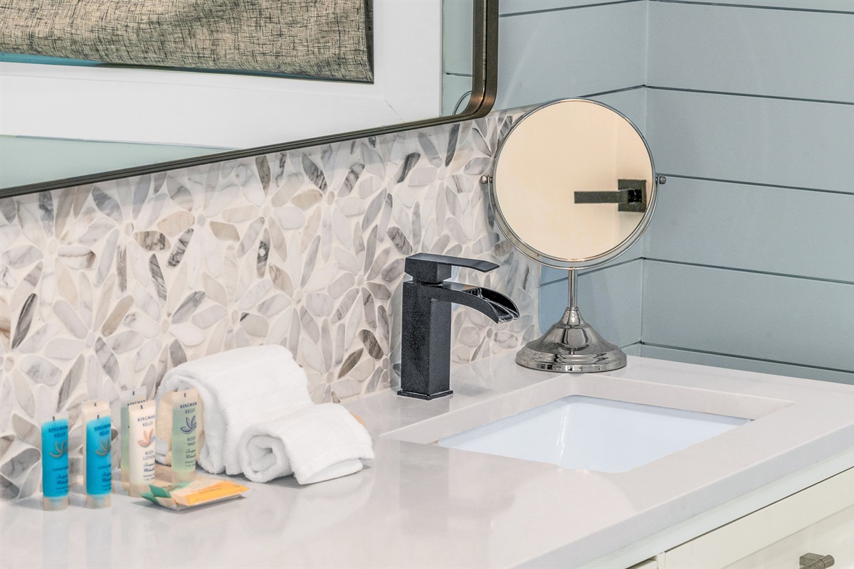 Primary Bathroom: This spa-inspired bathroom features sleek coastal design with a walk-in glass shower, modern fixtures and soft natural light- creating a serene retreat for relaxation and rejuvenation