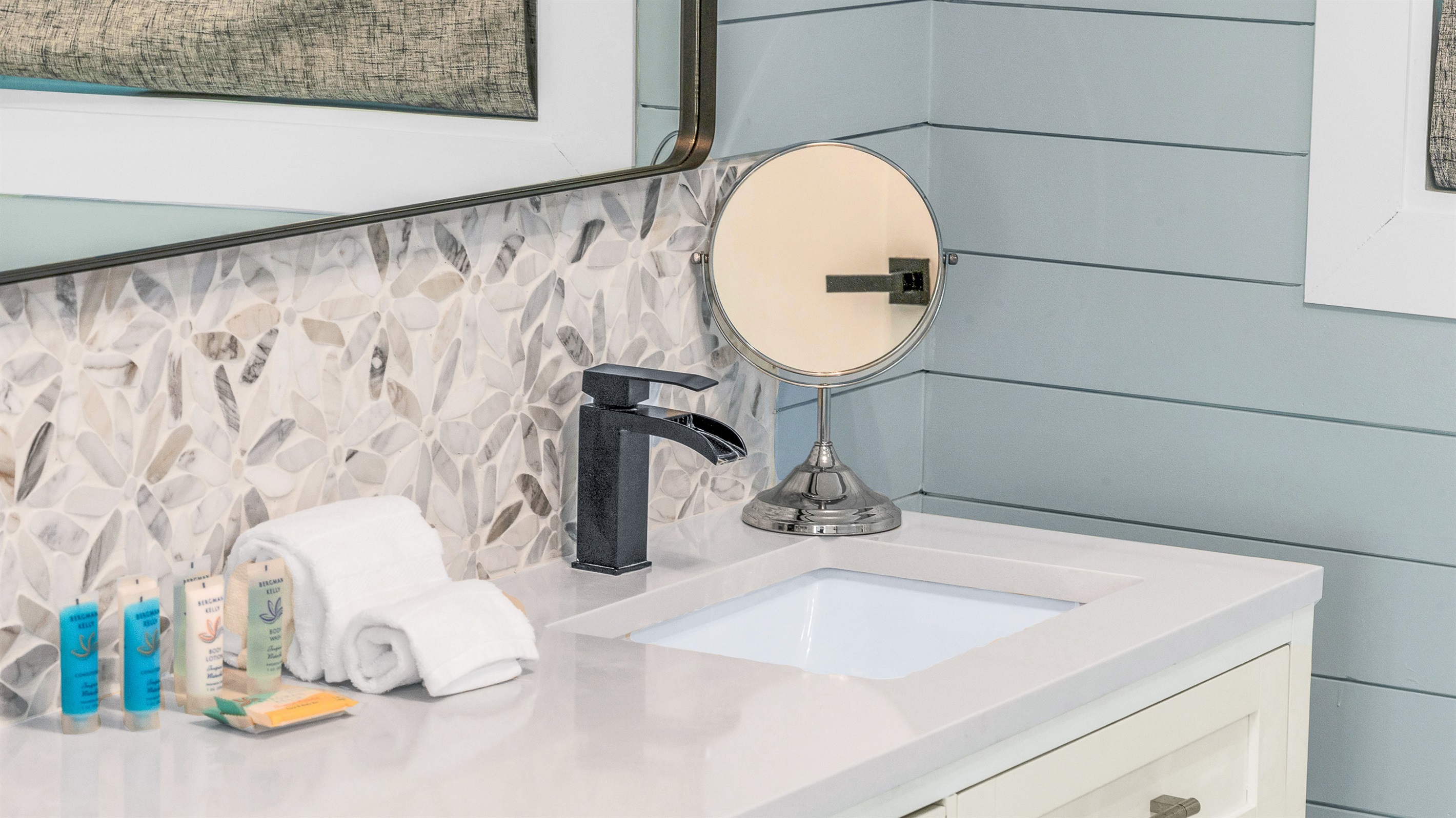 Primary Bathroom: This spa-inspired bathroom features sleek coastal design with a walk-in glass shower, modern fixtures and soft natural light- creating a serene retreat for relaxation and rejuvenation