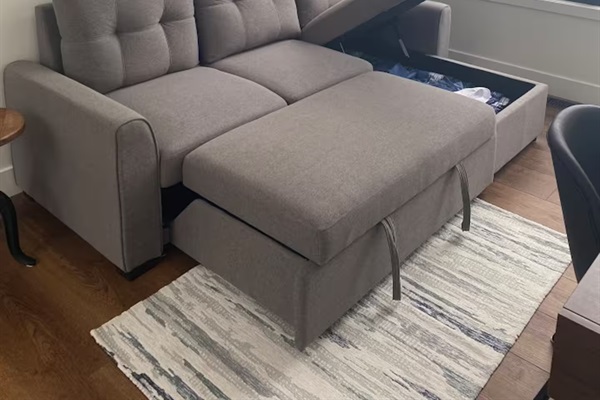 Sleeper sofa storage showing where to find bedding and linens when needed.