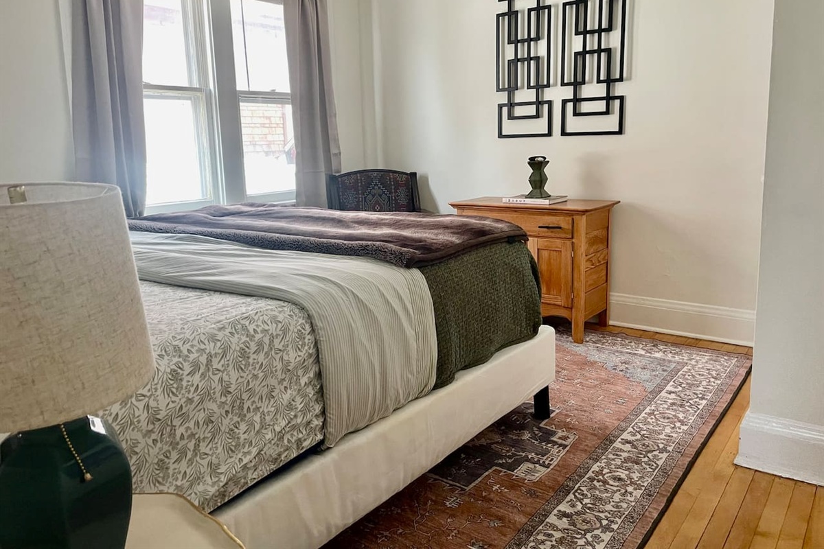 King bedroom with plush bedding, layered textures, and warm lighting—an inviting retreat for deep, restful sleep.