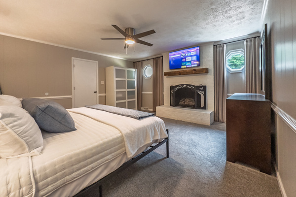 King bed, 55" Smart TV, ceiling fan, two led light nightstands with multiple charging ports, two multi light function lamps, blackout curtains, dresser, wardrobe closet, full length mirror, stylish brick fireplace - not in use.