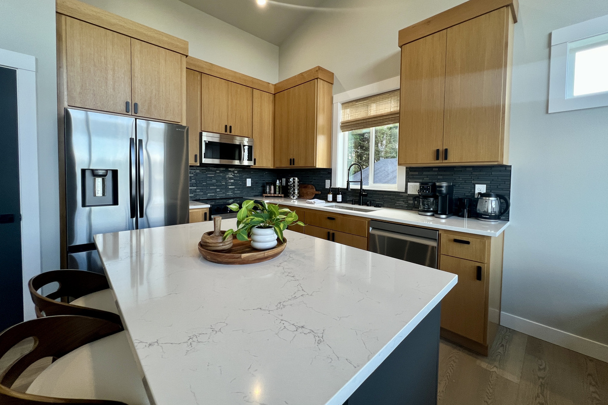 A gorgeous quartz island anchors the kitchen — gather, snack and pour your favorite drink.