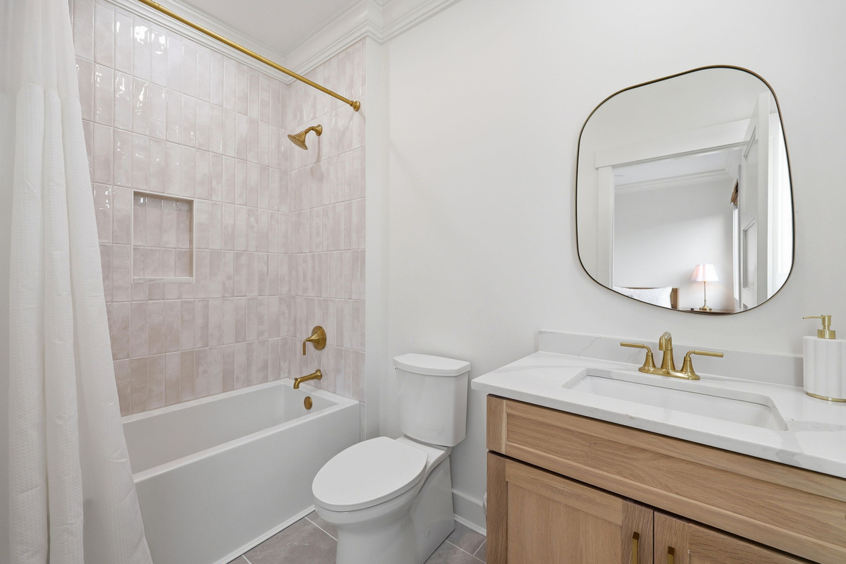 Second-floor bathroom with tub-shower combo and gold fixtures