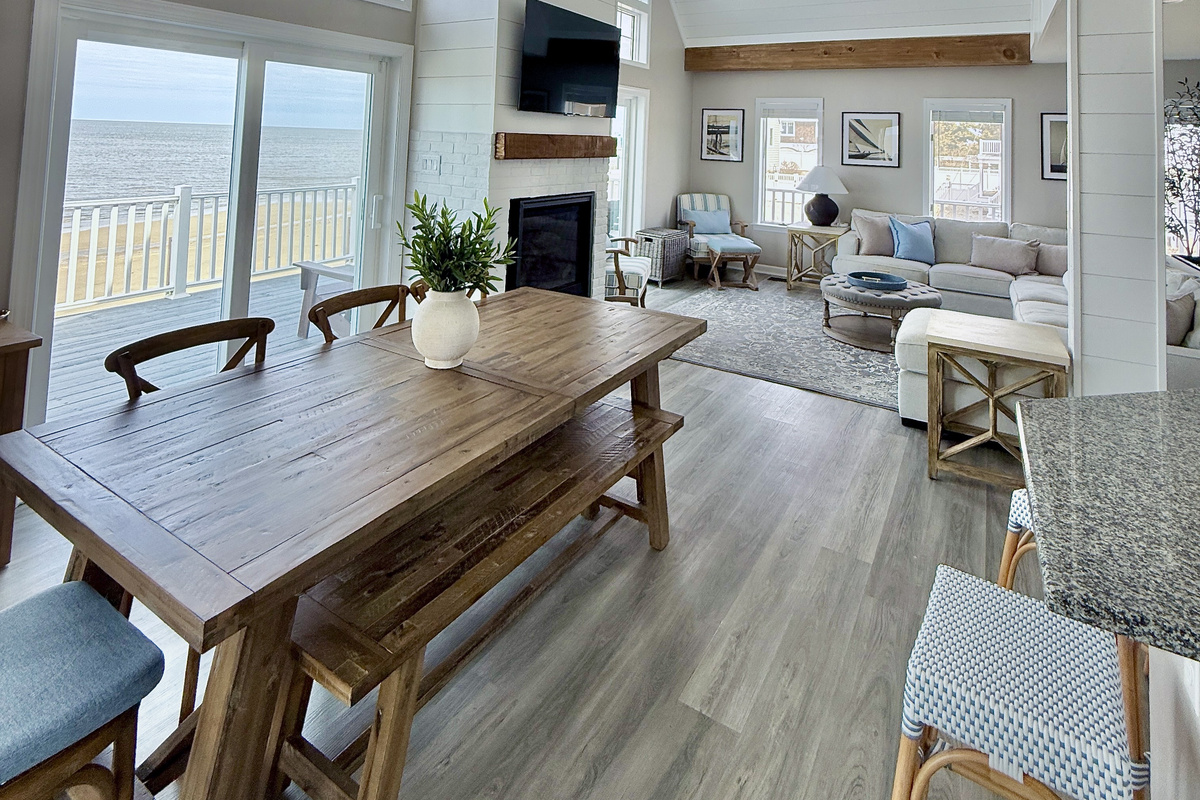 Experience effortless coastal living in our bright, open-concept living and dining area. Featuring warm wood accents, comfortable seating, and sliding glass doors that open directly to your private deck with stunning water views.