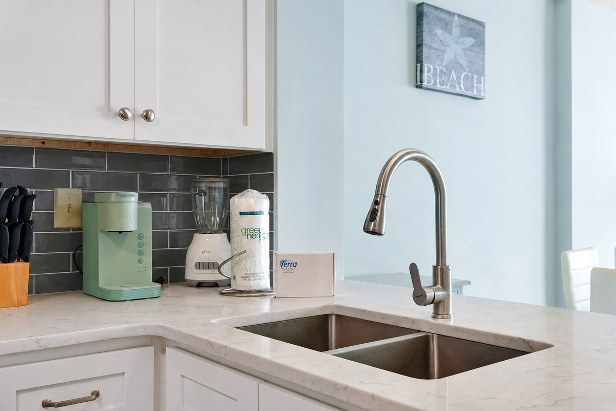 A modern kitchen featuring a sleek sink, coffee maker, blender, and an assortment of knives in various sizes—designed for convenience and efficiency in meal preparation.