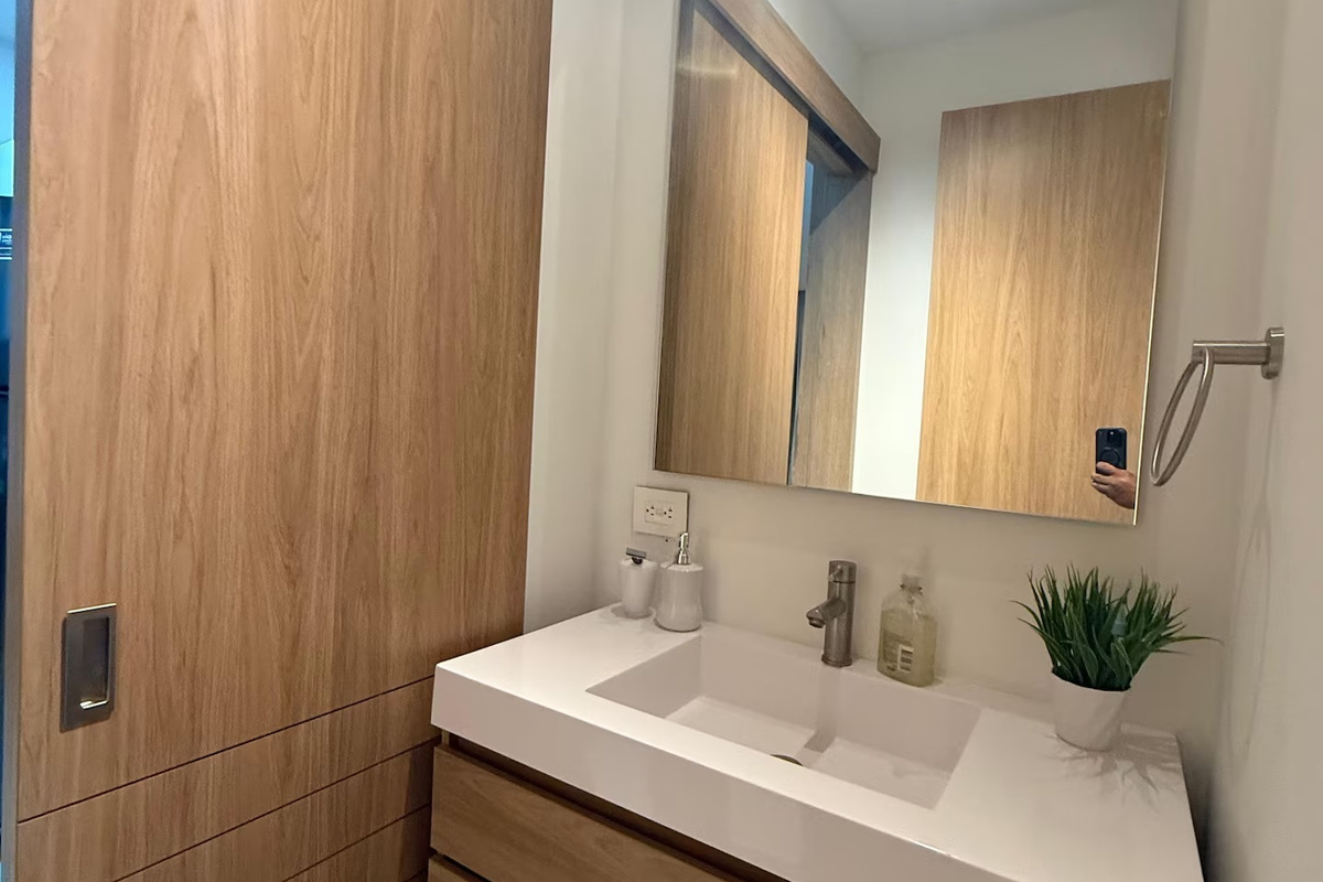 Comienza y termina el día con un baño práctico y cómodo, que incluye ducha con mampara de vidrio, un tocador luminoso y espacio de almacenamiento útil.