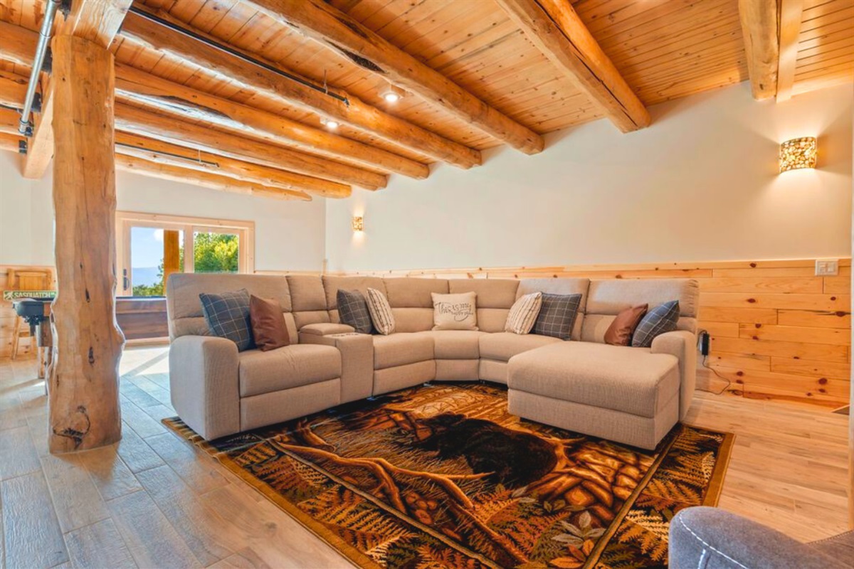 Entertainment-ready basement with sectional and TV.