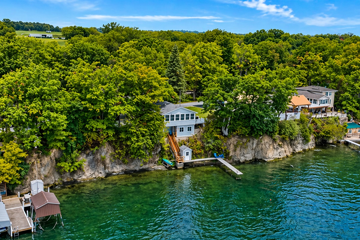 Soak in the breathtaking views of this cliffside cottage, perched right by the water with private dock access. Perfect for those seeking a secluded retreat surrounded by nature! 