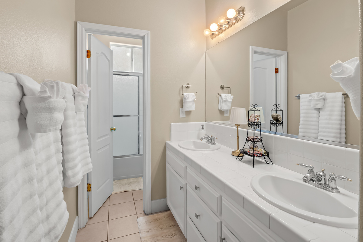Freshen up in this spacious bathroom featuring a double vanity, plenty of counter space, and bright lighting. With room for multiple guests to get ready comfortably, mornings are a breeze