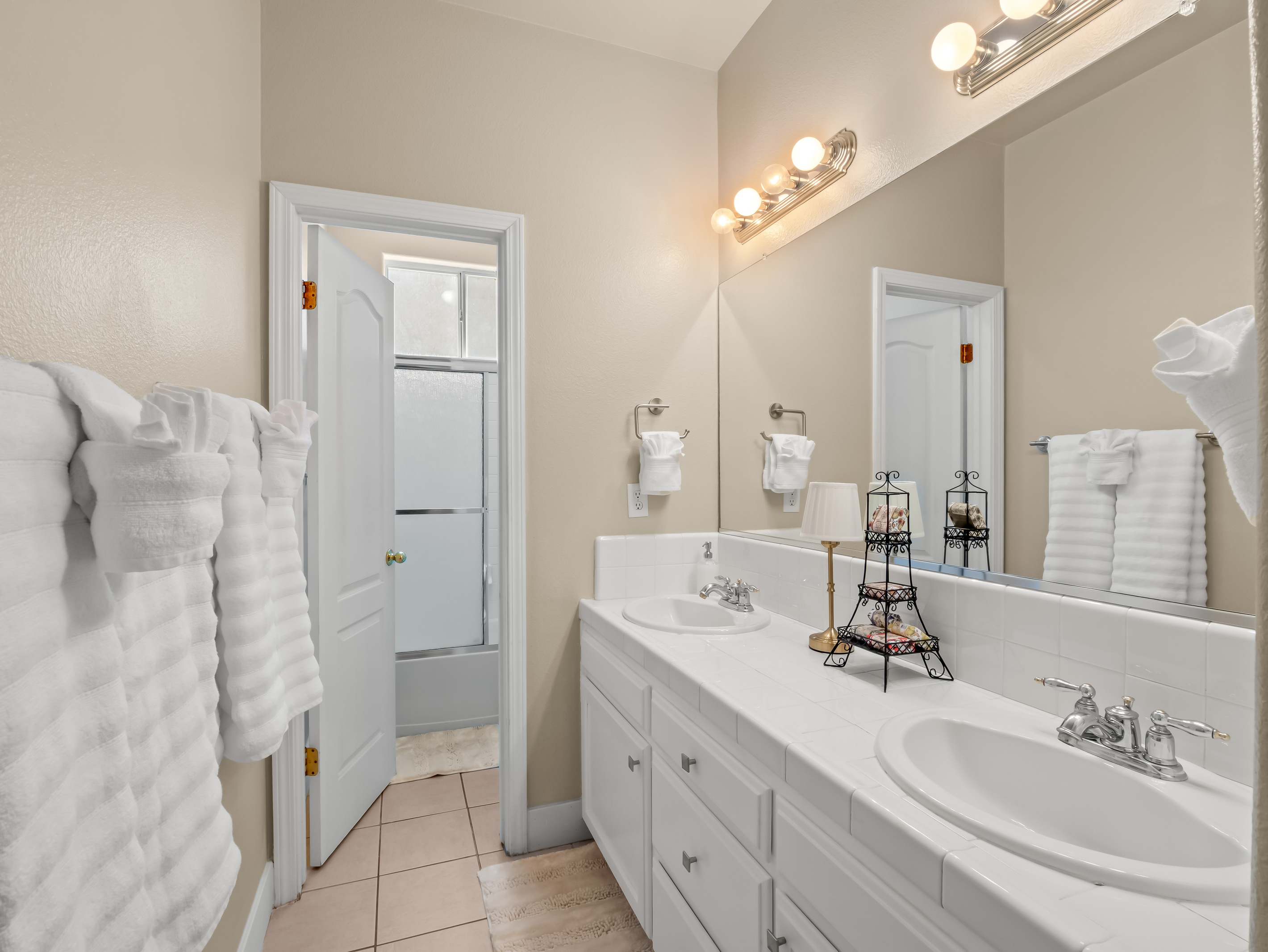 Freshen up in this spacious bathroom featuring a double vanity, plenty of counter space, and bright lighting. With room for multiple guests to get ready comfortably, mornings are a breeze