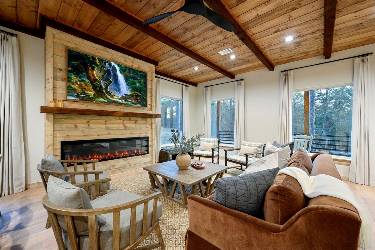 Gather around the fireplace in this open-concept living space 🔥