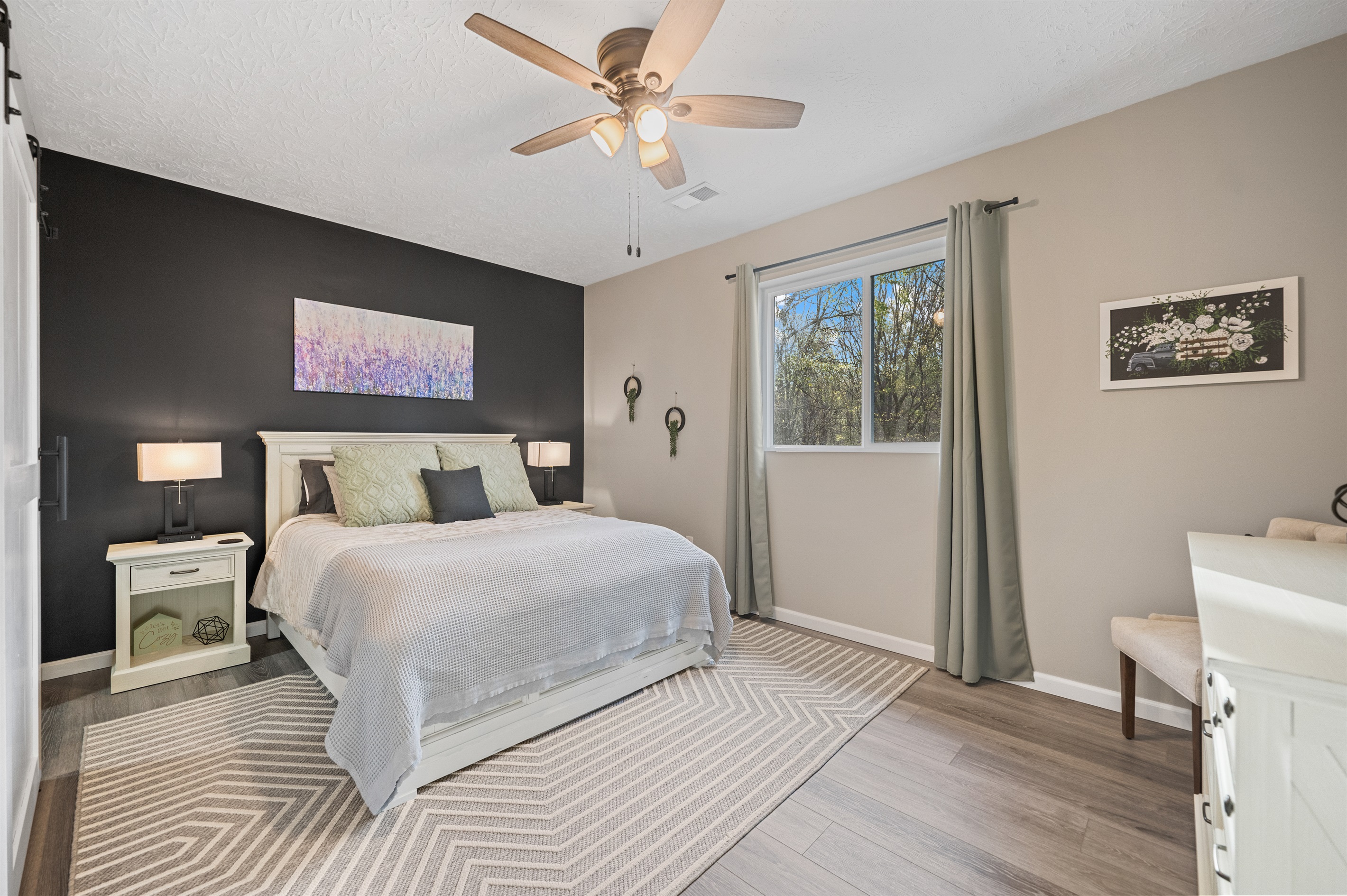 The upstairs queen bedroom features a comfortable queen bed, two USB-equipped lamps, and a walk-in closet, conveniently located next to the full bathroom.