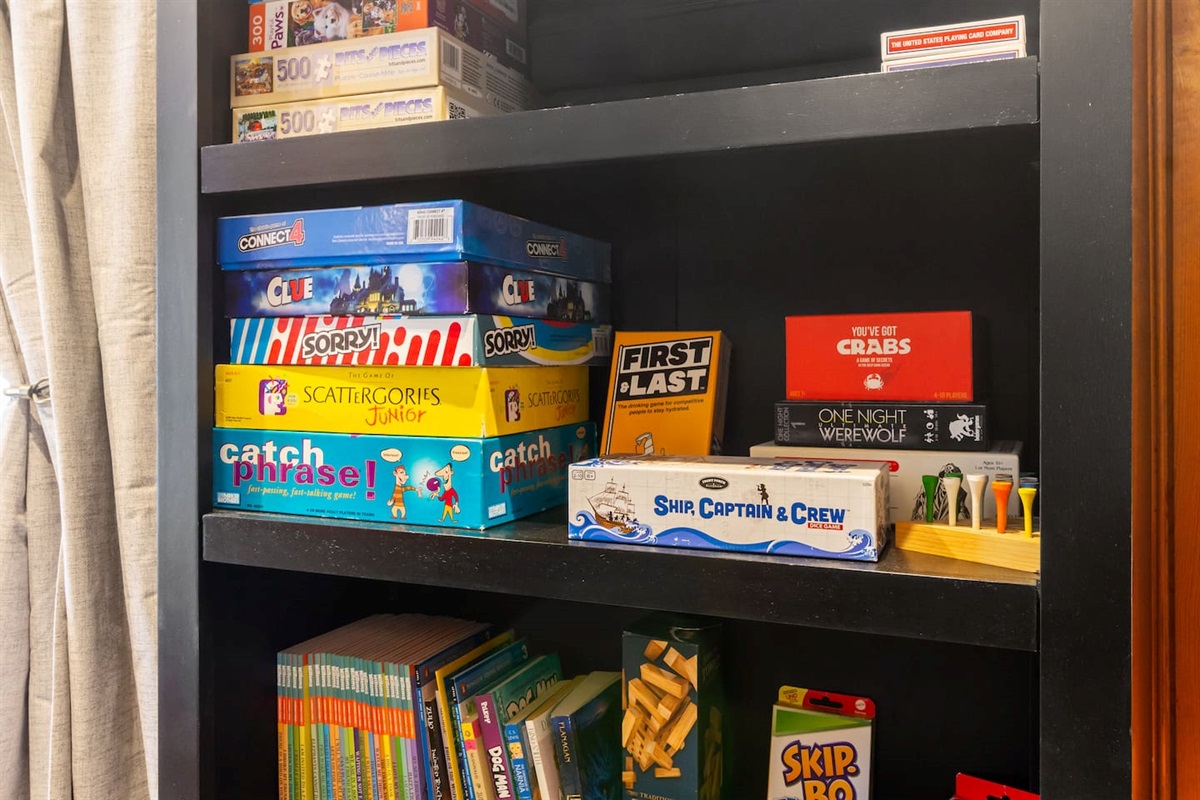 Children's books for entertainment away from the screens. Off-brand Jenga, and several toys in the cupboard below.