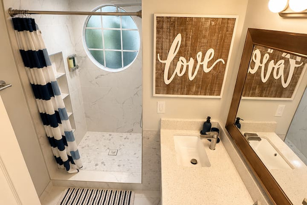 Bright bathroom with a walk-in shower, spacious vanity, and modern finishes.