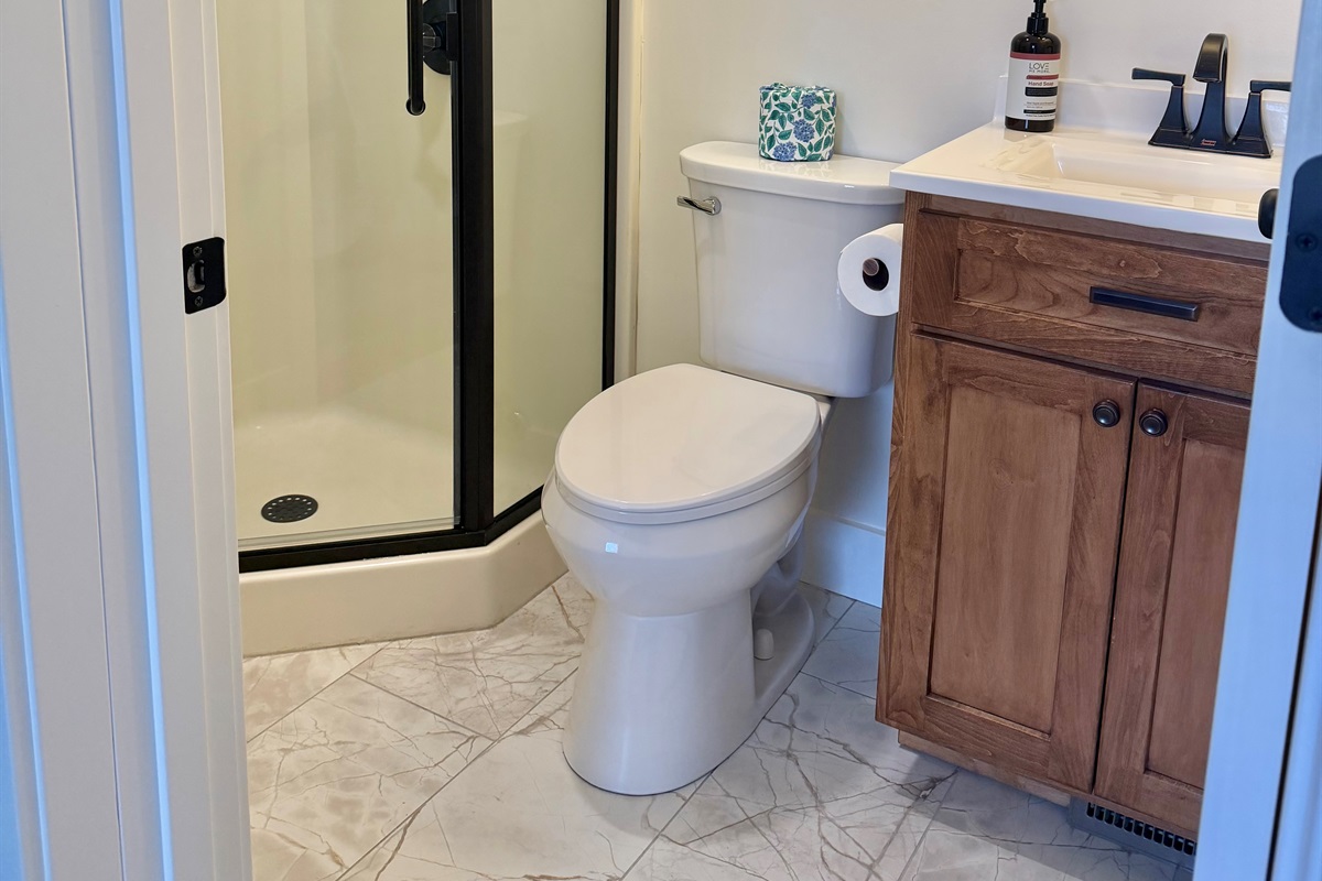Updated ¾ bathroom featuring a walk-in shower and custom cabinetry