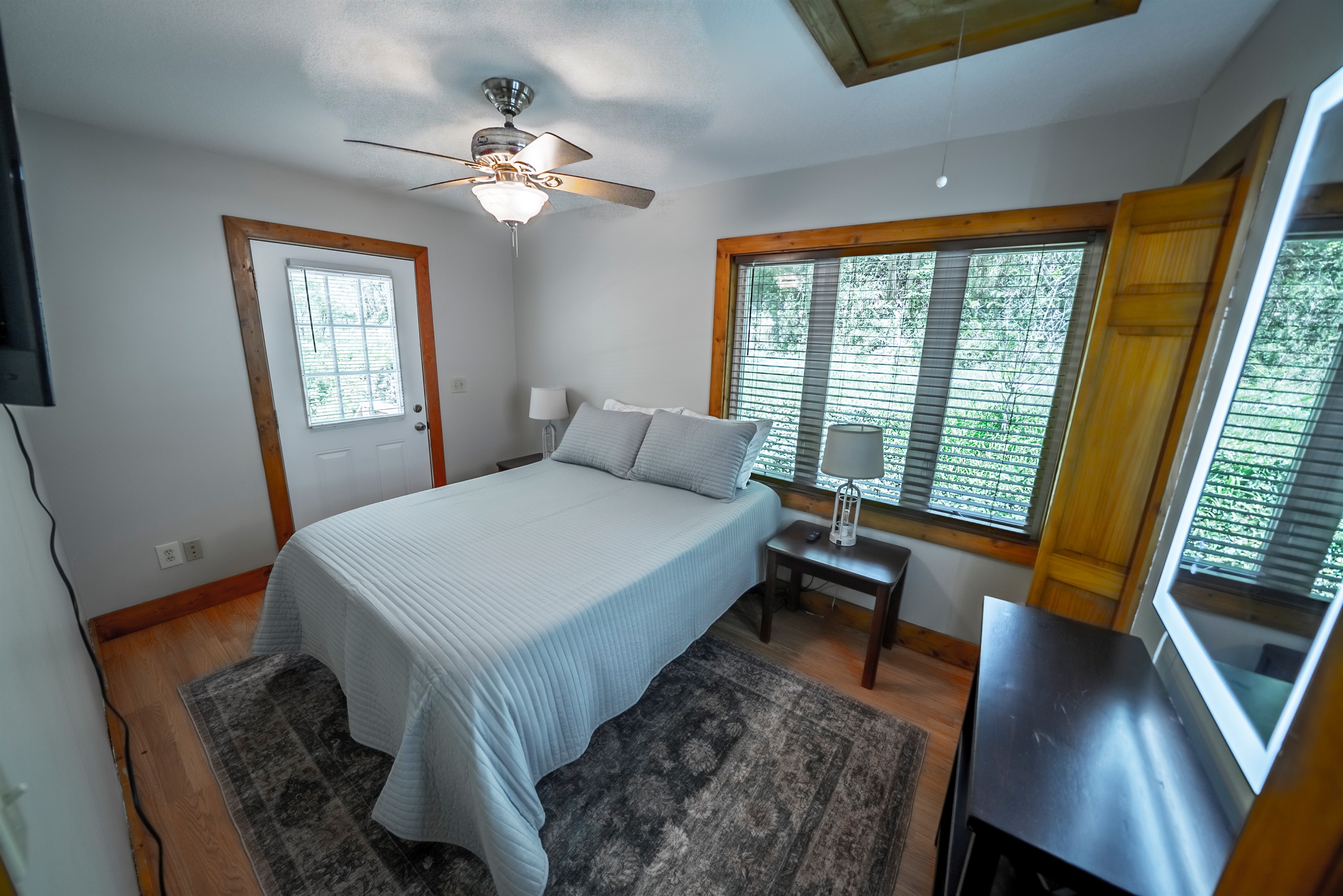 A cozy queen bedroom with everything you need, including a Smart TV, ceiling fan, and direct access to the outdoor deck.