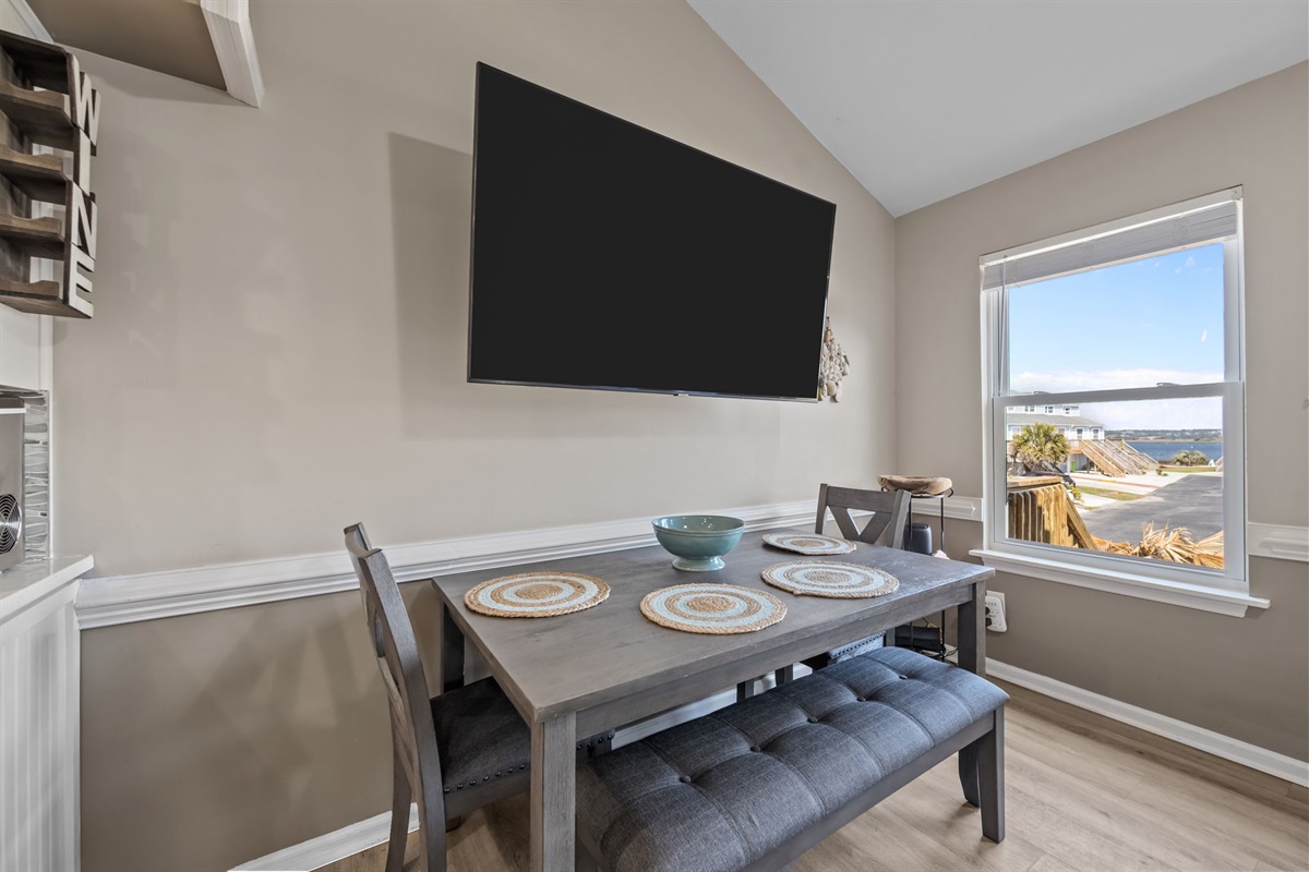 Dining area with wall mounted TV and water view