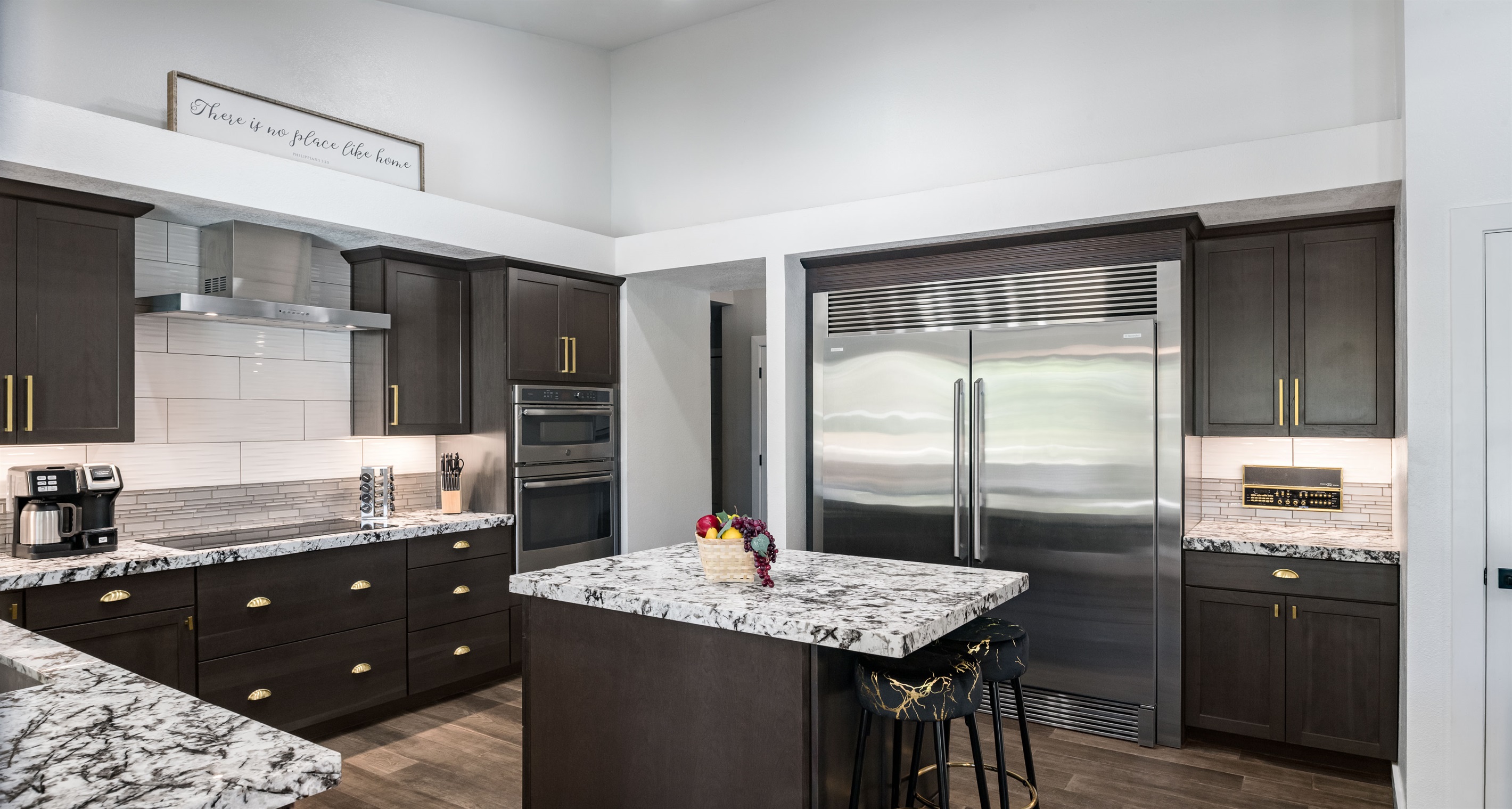 The gourmet kitchen includes high-end appliances, a commercial-grade fridge, and a sleek island perfect for family meals or entertaining.