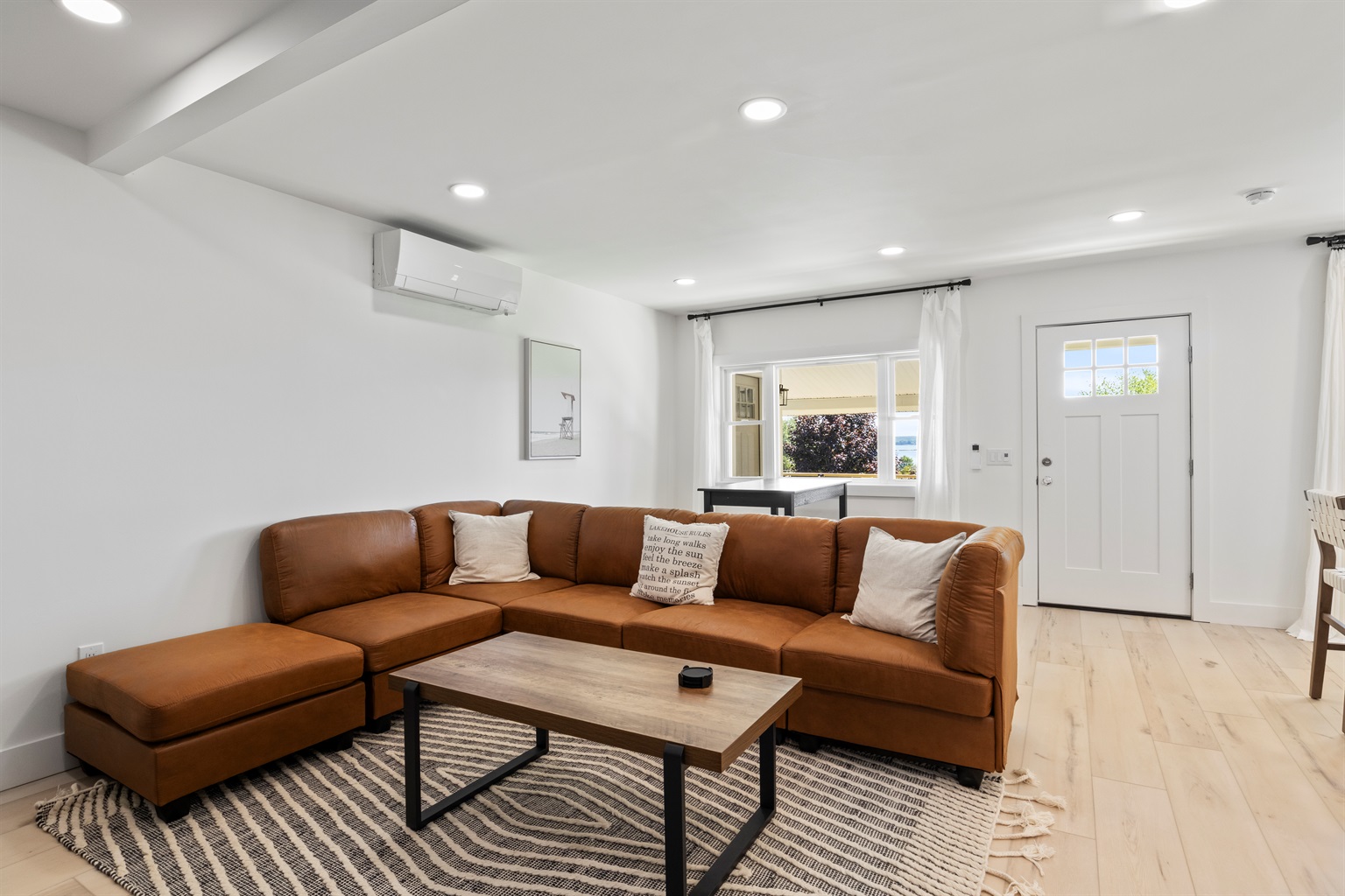 Open concept floorplan with kitchen, living room and dining table w/ 4 stools