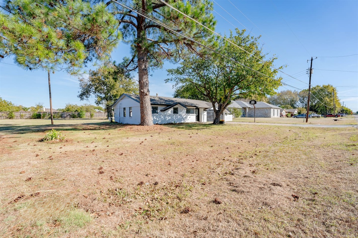 Spacious corner-lot home in Grand Prairie with mature trees, long driveway parking, and a bright, family-friendly layout inside.