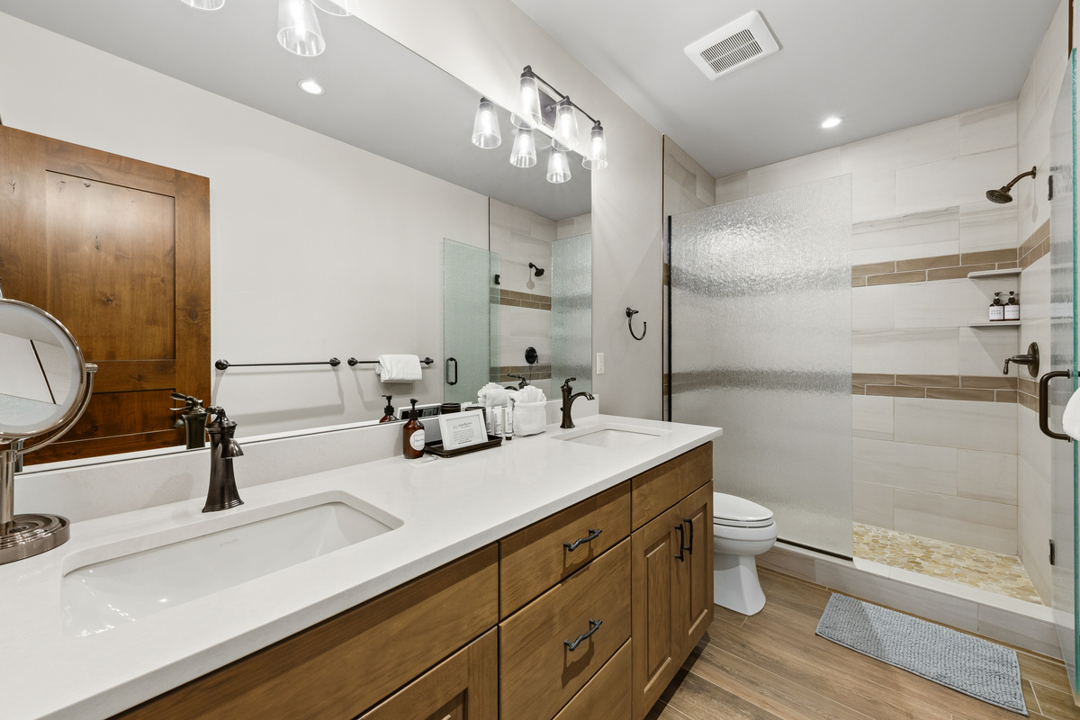 Guest bathroom #2 in the mini suite with dual vanity sinks and walk-in shower