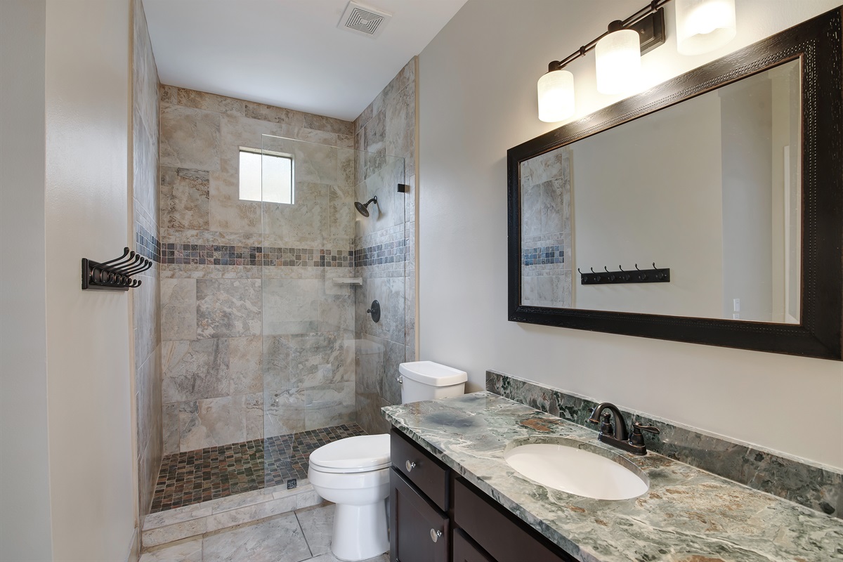 Main‑level bathroom with walk‑in shower and granite vanity
