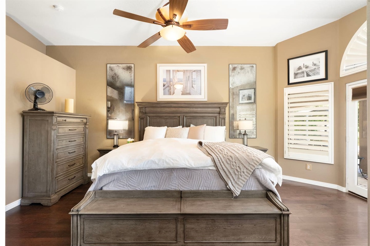 The primary bedroom is your private sanctuary — a full dresser, dual nightstand lamps, and a cozy throw blanket mean everything is in place for a restful, hotel-quality stay.