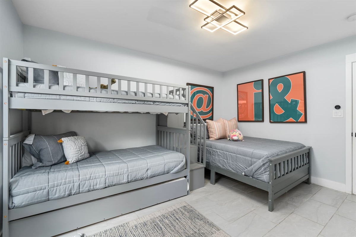 Spacious setup with bunk and trundle combo plus a cozy single bed.

