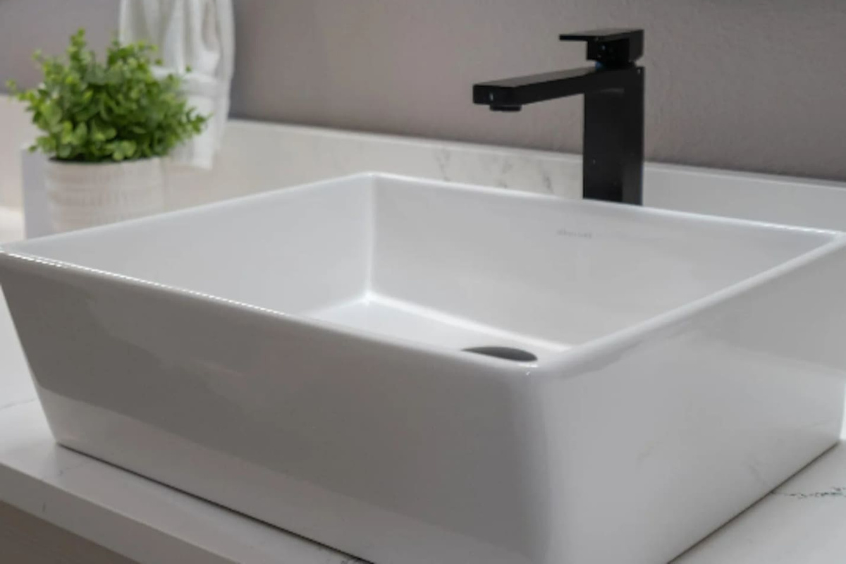 A sleek vessel sink and matte black fixtures add a modern touch to the bathroom details.