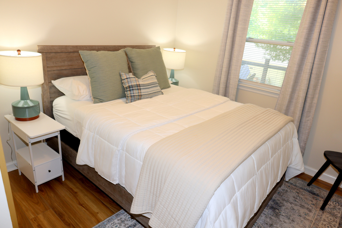 Peaceful second bedroom with soft linens and natural light