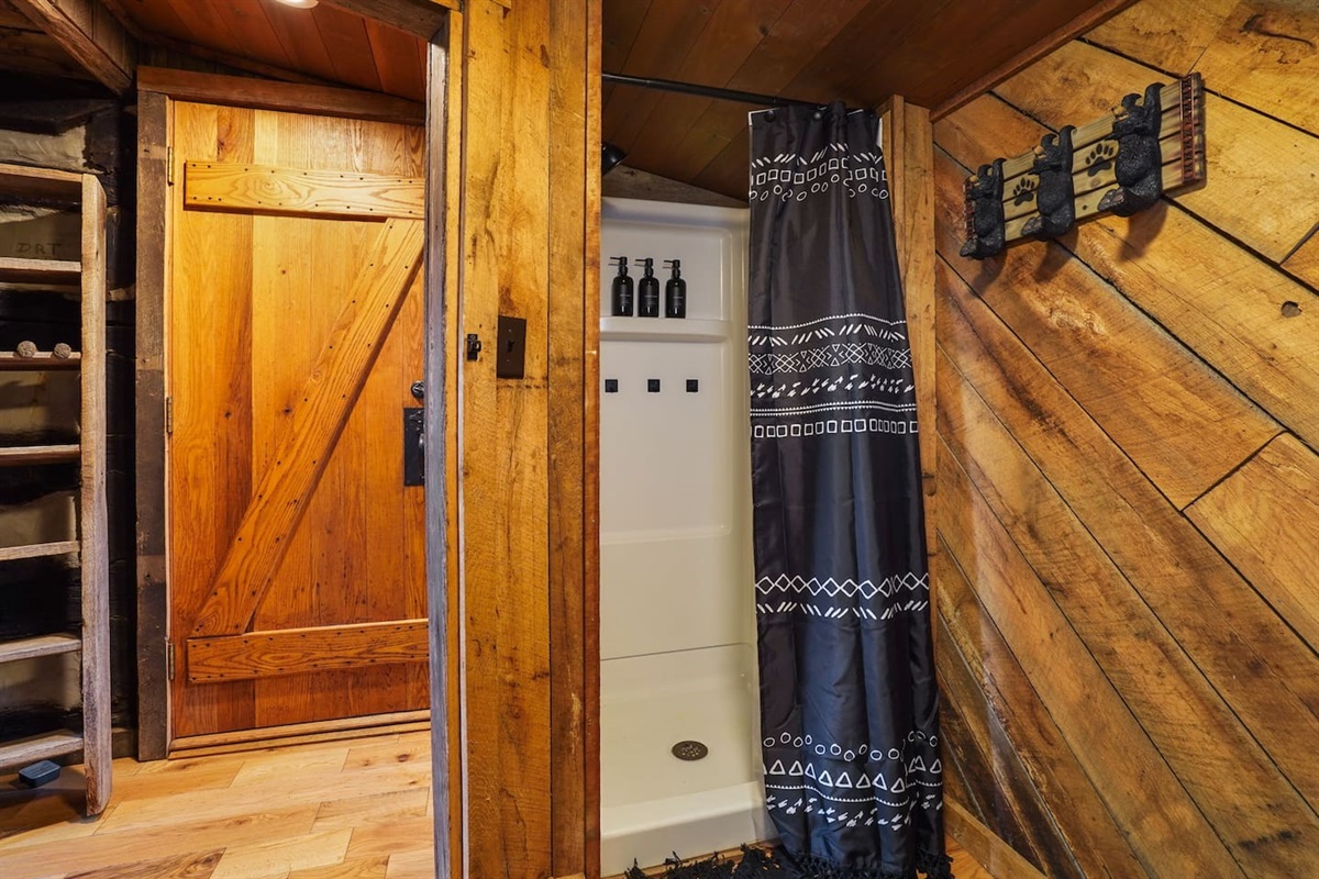 Standing shower equipped with shampoo, conditioner, and body wash.