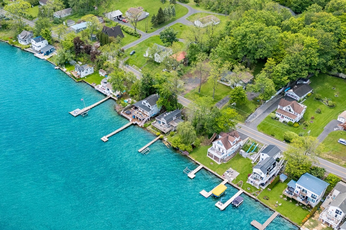 Aerial shot showcasing expansive lakefront entertaining space, hot tub, and private dock for the ultimate getaway 🎯🌊🍹