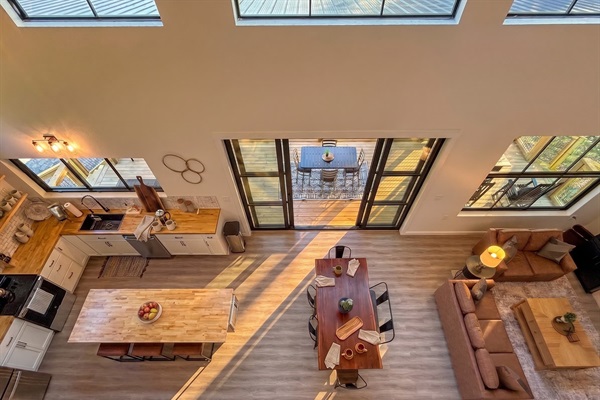 Open-concept great room from above, soaring ceilings, skylights, and a 12-foot slider framing Douglas Lake.