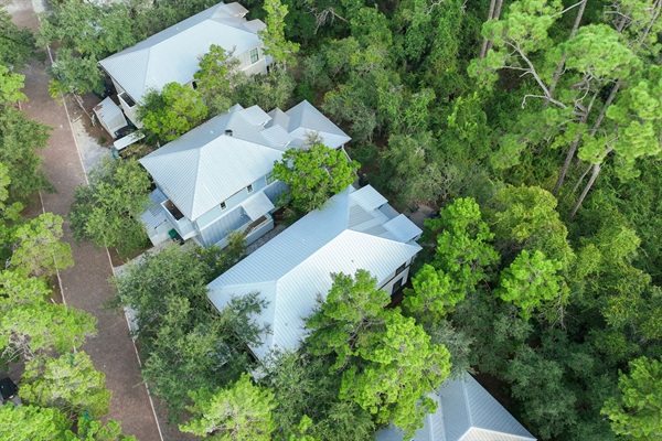 Pictured on the right, Zee by the Sea is nestled along a lush wooded backdrop, creating both privacy and a tranquil retreat. This peaceful setting lets you relax and unwind while still being just minutes from sugar-white sands and resort-style pool.